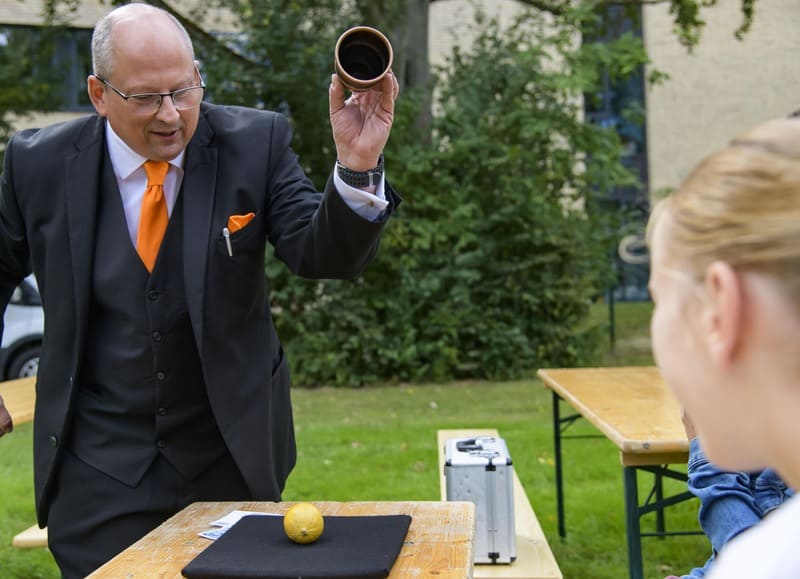 Professioneller Zauberer bei einer Firmenfeier mit erwachsenem Publikum