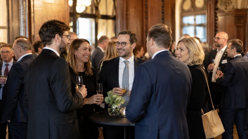 Empfang bei einem Firmenjubiläum mit Gästen und Sektgläsern
